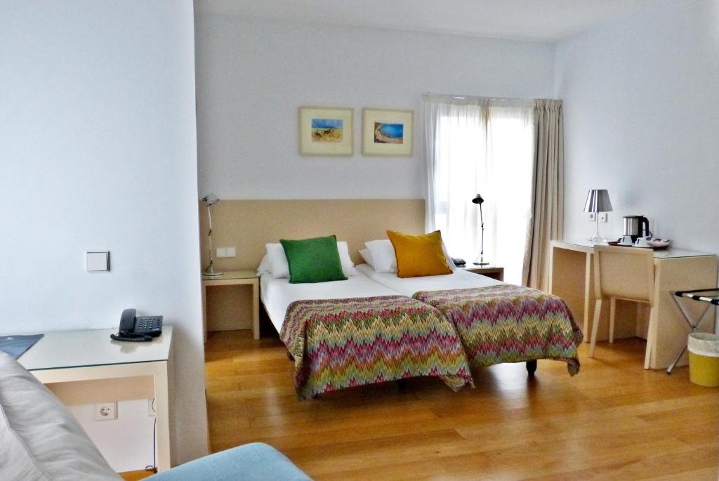 pokój hotelowy z łóżkiem i oknem w obiekcie Hotel Apartamentos Patagonia Sur w Kadyksie