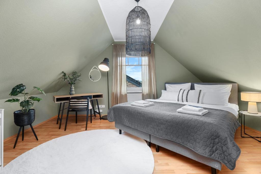 a bedroom with a bed and a table and a window at JOOYFUL STAYS Cozy Home in Kevelaer