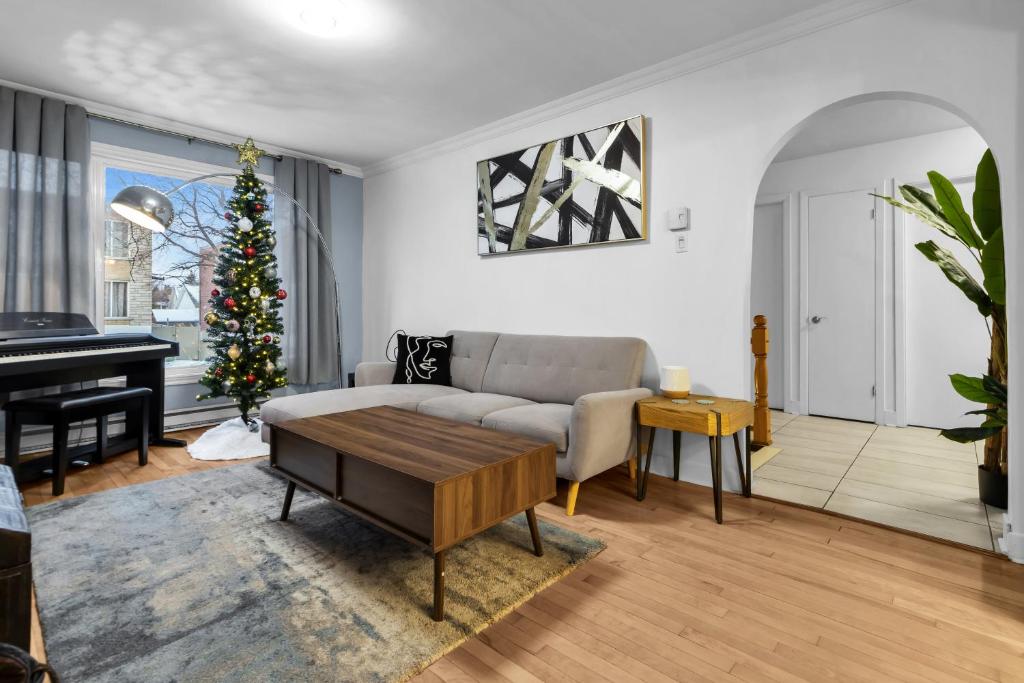 a living room with a couch and a christmas tree at COSY 3 BEDROOMS Montreal in Montréal