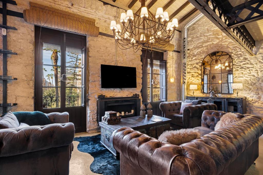 a living room with leather furniture and a fireplace at Palacio Sempere in Alicante