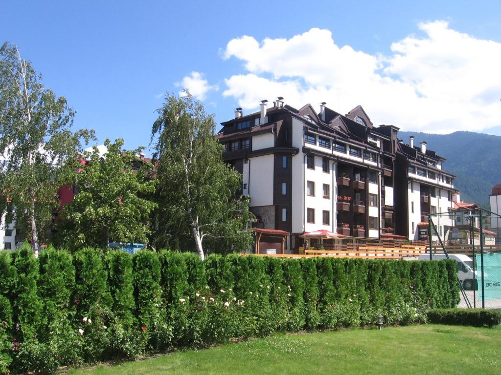 un hotel con un seto frente a un edificio en Apart Hotel Comfort, en Bansko