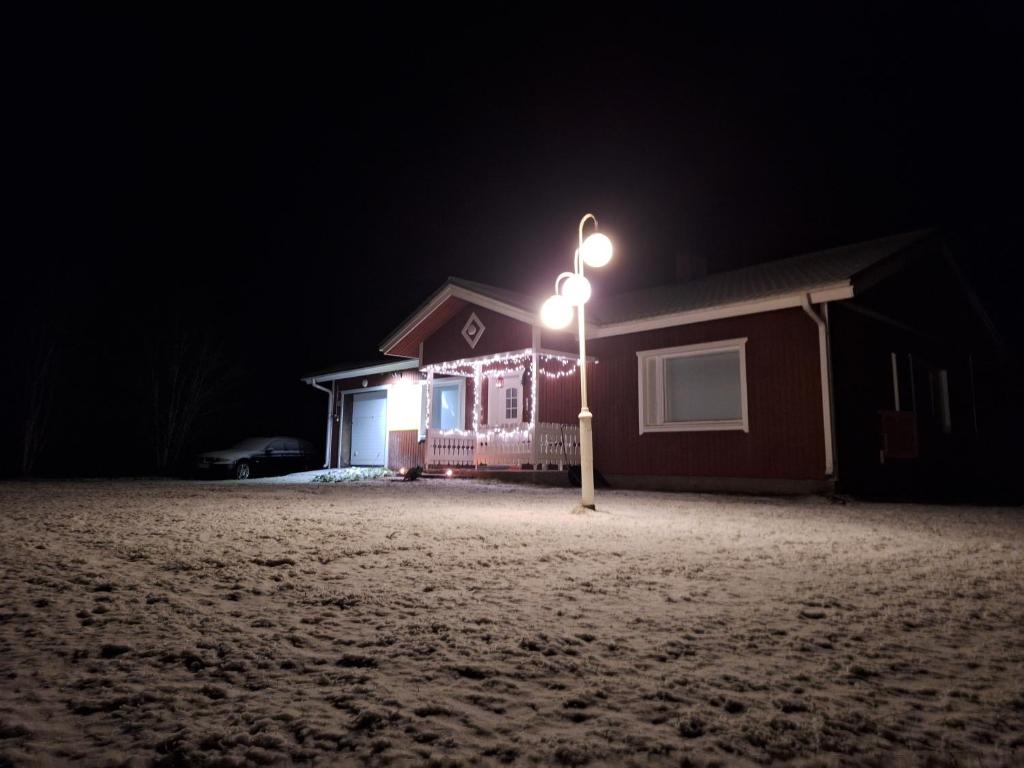 un lampione di fronte a una casa di notte di Sunin Tupa a Rantsila