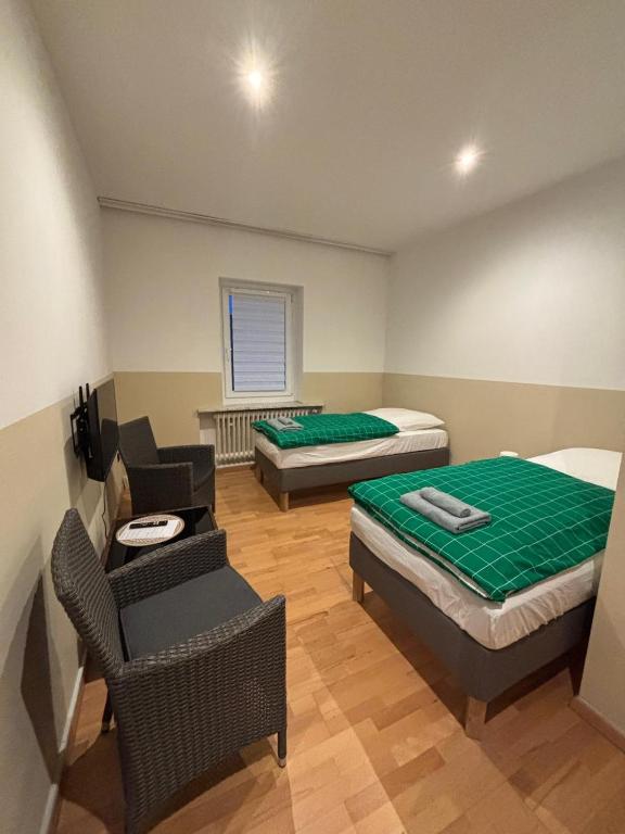 una camera con due letti, un divano e una sedia di Doppelzimmer-TV-Bad- Kühlschrank-8 a Meine