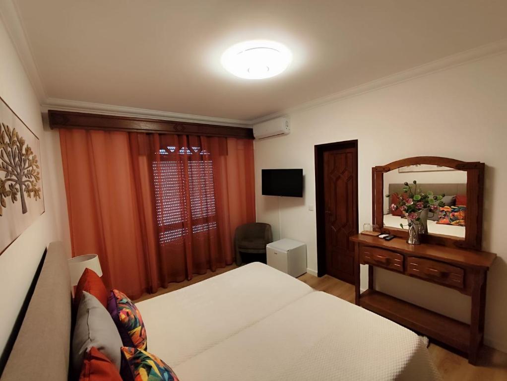 ein Hotelzimmer mit einem Bett und einem Spiegel in der Unterkunft Residencial Pôr do Sol in Couço