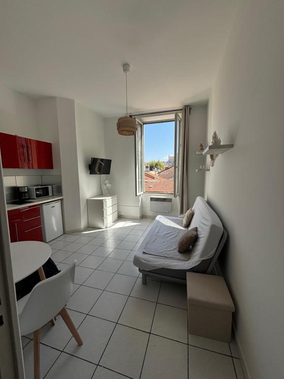 une chambre avec un lit, une table et une fenêtre dans l'établissement Le 23B, à Marseille