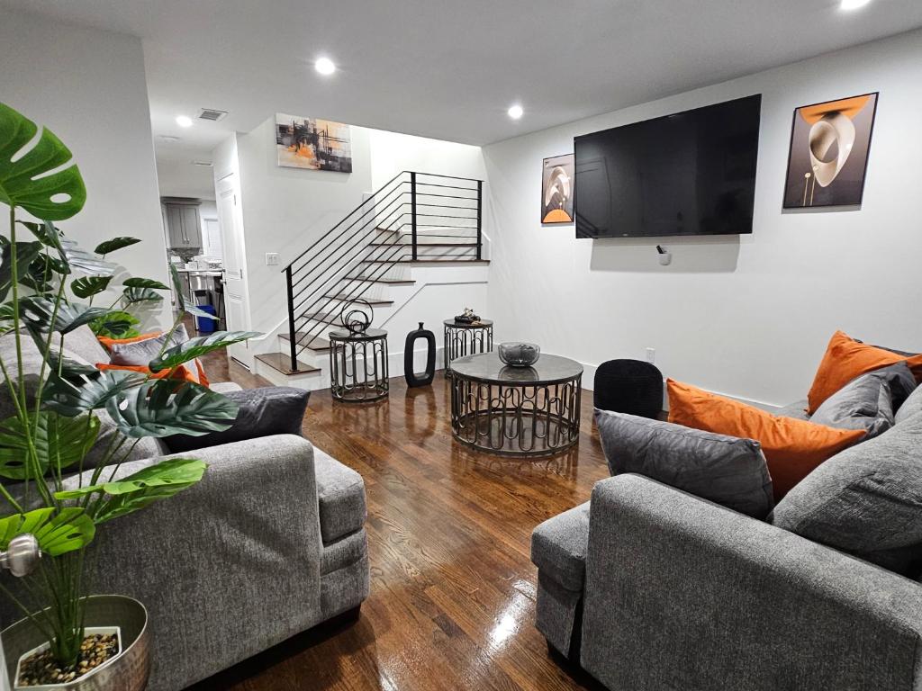 a living room with two couches and a flat screen tv at Brand New 4BR House 20Min Downtown Boston in Boston