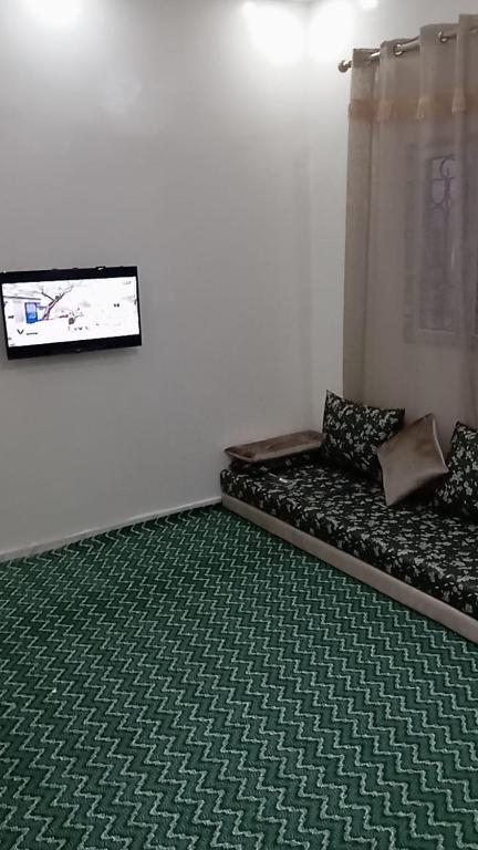 a room with a couch with a green carpet at socogimps in Nouakchott