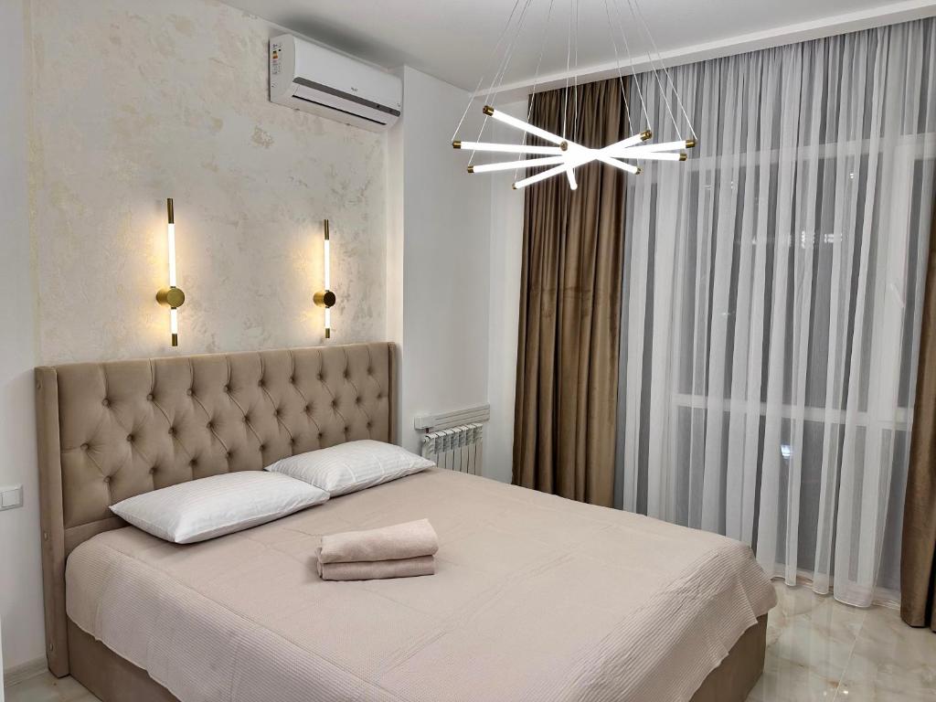 een slaapkamer met een groot bed met een groot raam bij Elen's Bi Residence in Batoemi