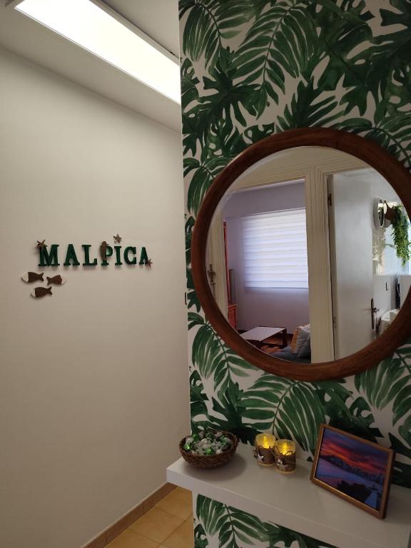 a mirror on a wall with a green leafy wall at Camiño dos faros Malpica in Malpica