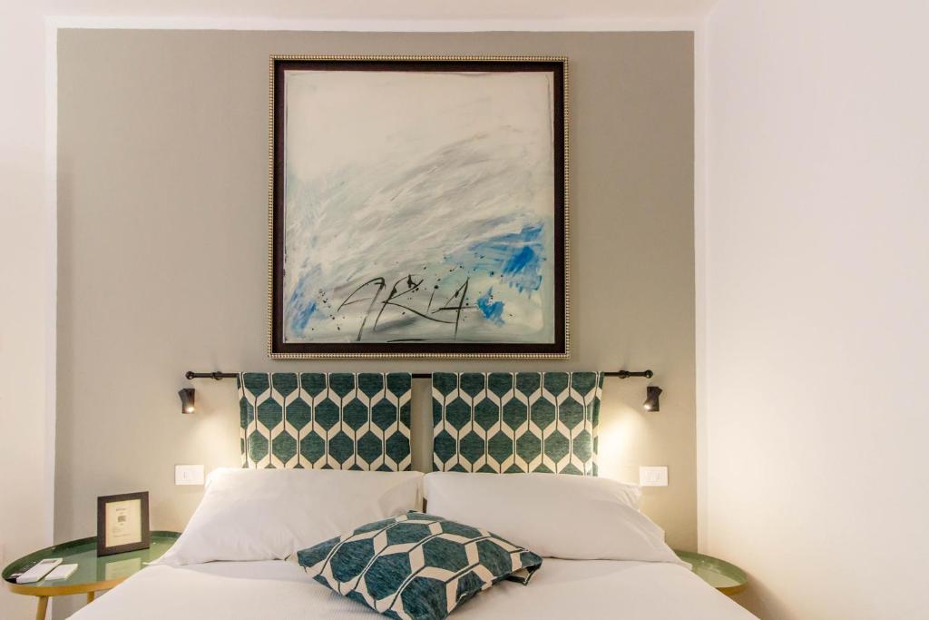 a bedroom with a bed with a painting above it at P&M Belvedere Rooms in Olbia