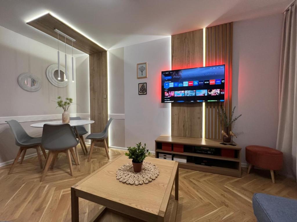 a living room with a table and a tv on a wall at "Ostoja Mazury"- Przy Plaży in Mrągowo