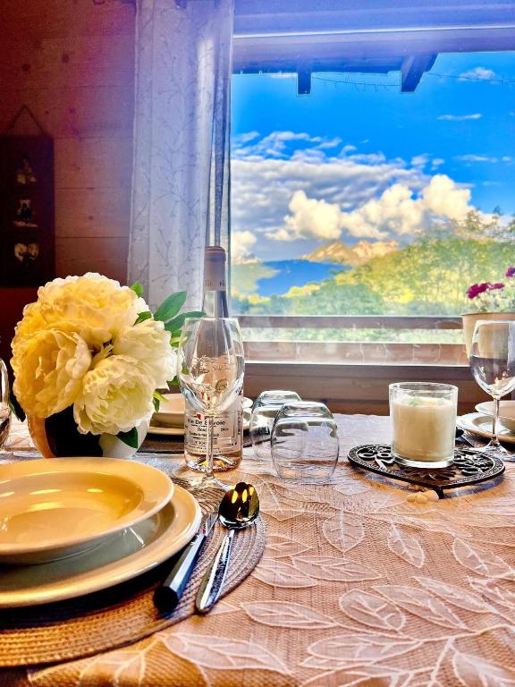 une table avec des assiettes, des verres et une fenêtre dans l'établissement Charming family Chalet for 8 people, with private Hot Tub, à Les Clefs