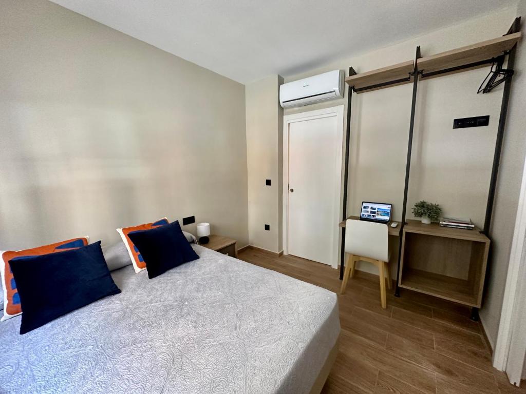 バレンシアにあるBlue House Valenciaのベッドルーム1室(青い枕とデスク付)