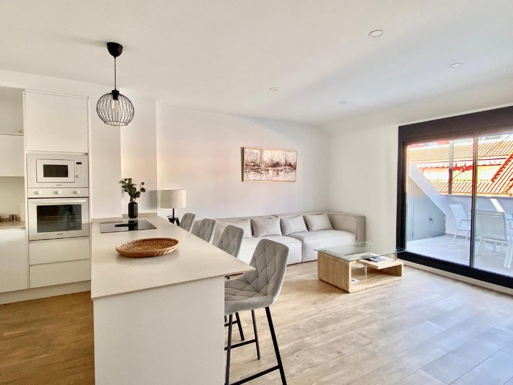 a kitchen and living room with a couch and a table at Luxury penthouse with pool near Fuengirola beach in Fuengirola
