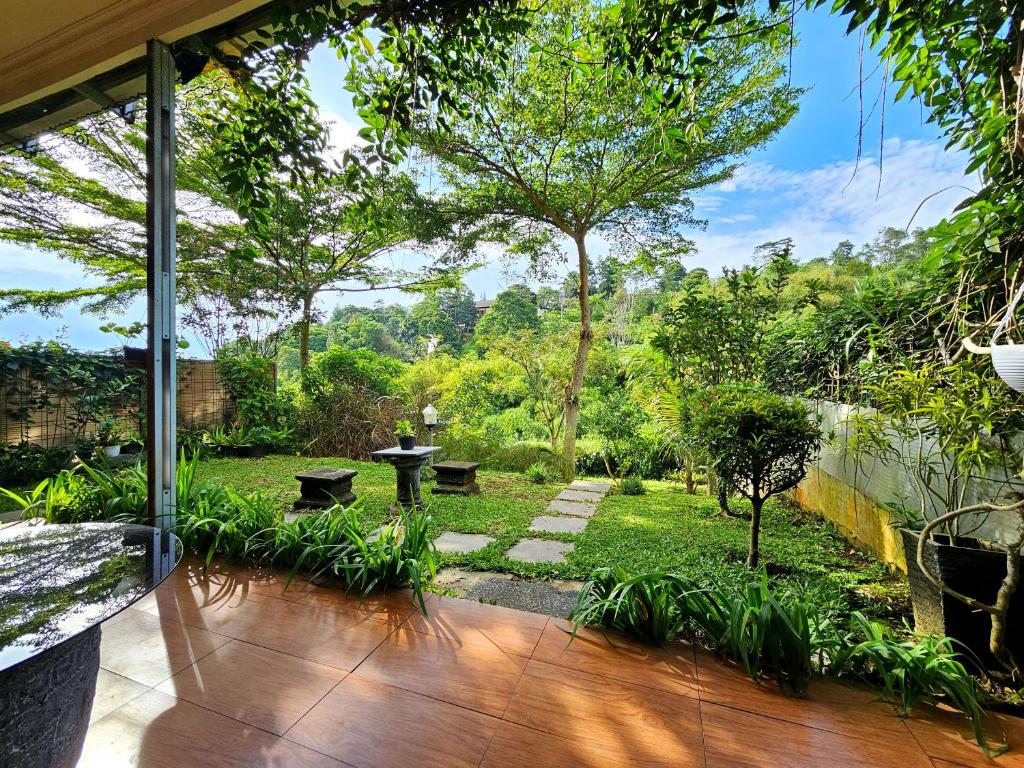 a view of a garden from the inside of a house at The Wiltshire Dago Pakar - Hillside Villa MAX 12 ORANG in Bandung
