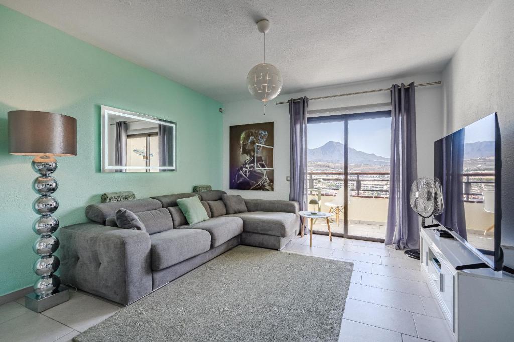 a living room with a couch and a tv at 14th floor Sea View in Adeje