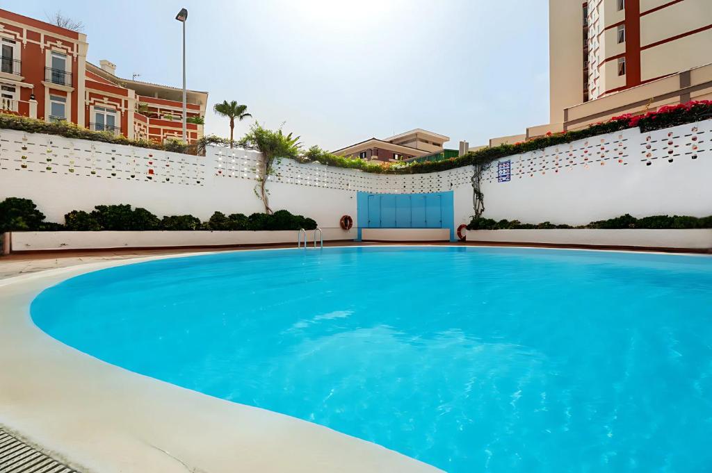 una grande piscina blu in un edificio di Elegancia y Confort en Playa Jardín a Puerto de la Cruz