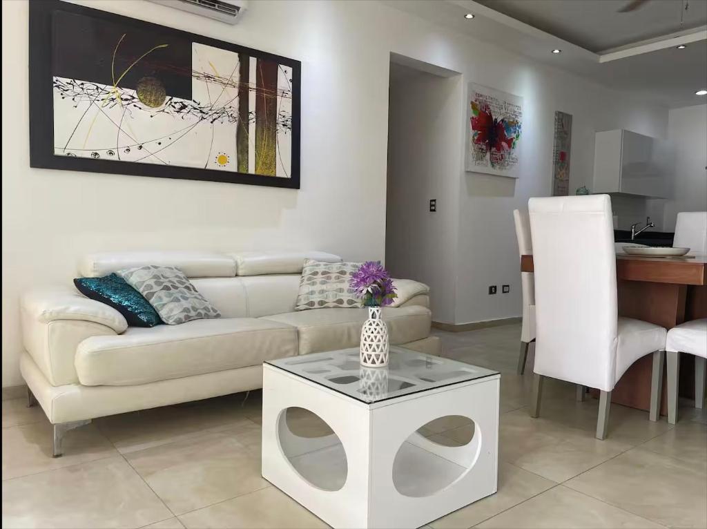 a living room with a couch and a table at Central Luxury Apartment Playa del Carmen in Playa del Carmen