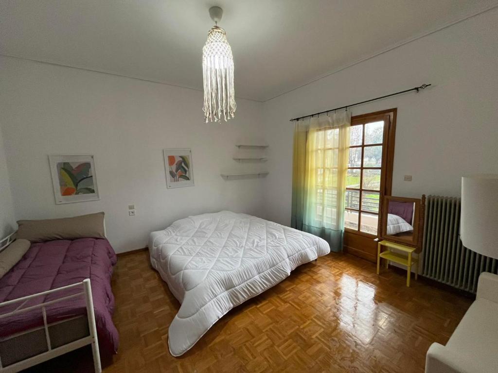 a bedroom with two beds and a chandelier at Σπίτι κοντά στο μύλο ξωτικών in Tríkala