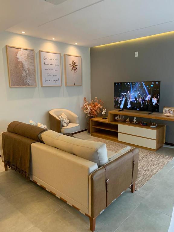 a living room with a couch and a flat screen tv at Condominio Nova angra in Angra dos Reis