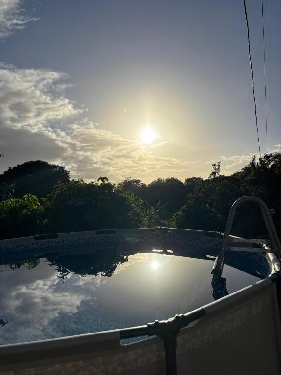 a swimming pool with the sun reflecting on the water at La Jéméli in Grand-Bourg