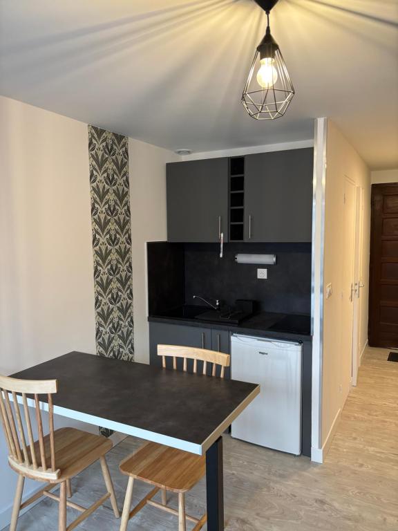une cuisine avec une table et des chaises dans une pièce dans l'établissement Studio Tezoto, à Briançon