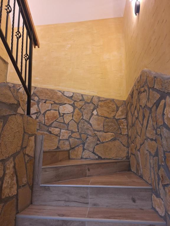 a stone wall with a bench in a staircase at Apartman Crni bor 2 Tara in Kaludjerske Bare