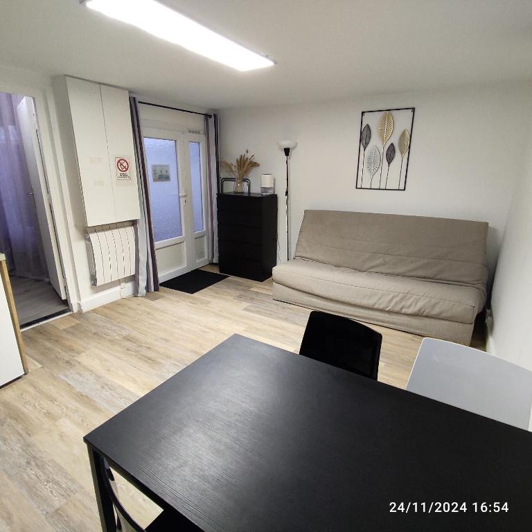 un salon avec un canapé et une table dans l'établissement Maison ancienne avec patio sans vis à vis, à Gagny