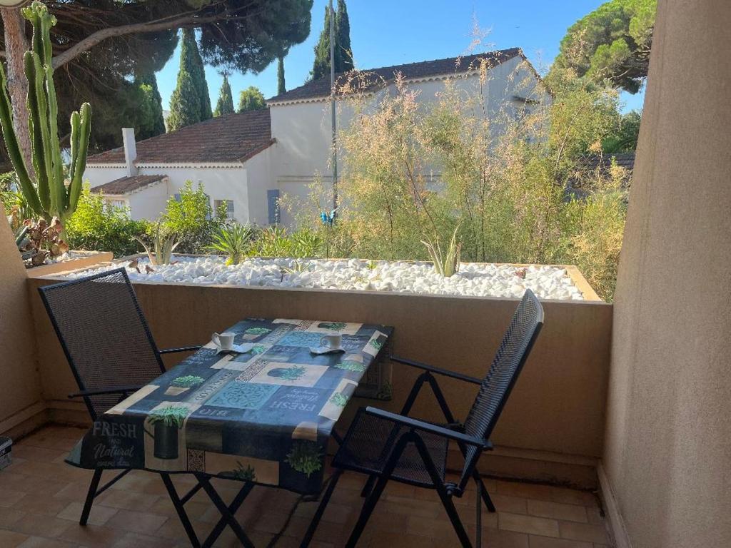 une table et deux chaises assises sur un balcon dans l'établissement Cavalaire, tout à proximité, à Cavalaire-sur-Mer