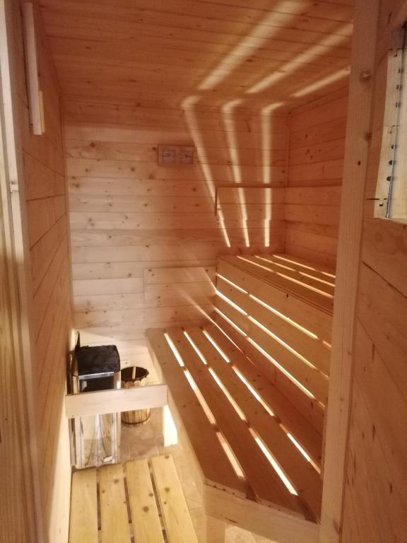 a sauna with a bench in a wooden room at Apartman LAVANDA in Šumarak