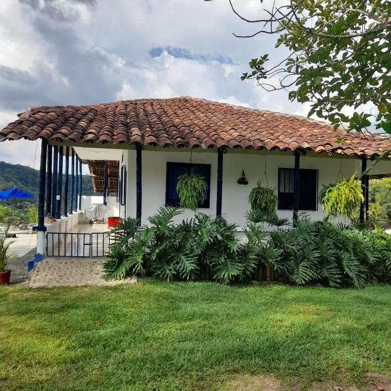 a small white house with a tiled roof at Casa Alto Bonito in Quimbaya