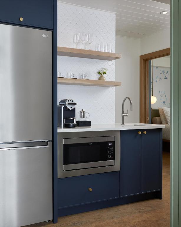 a kitchen with blue cabinets and a stainless steel appliance at The Beach Motel in Southampton