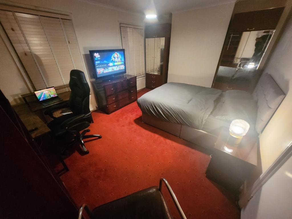 a hotel room with a bed and a television at Home away from Home in Thornton Heath