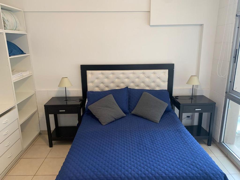 Un dormitorio con una cama azul con dos mesitas de noche. en Beautiful apartment in the heart of Buenos Aires, en Buenos Aires