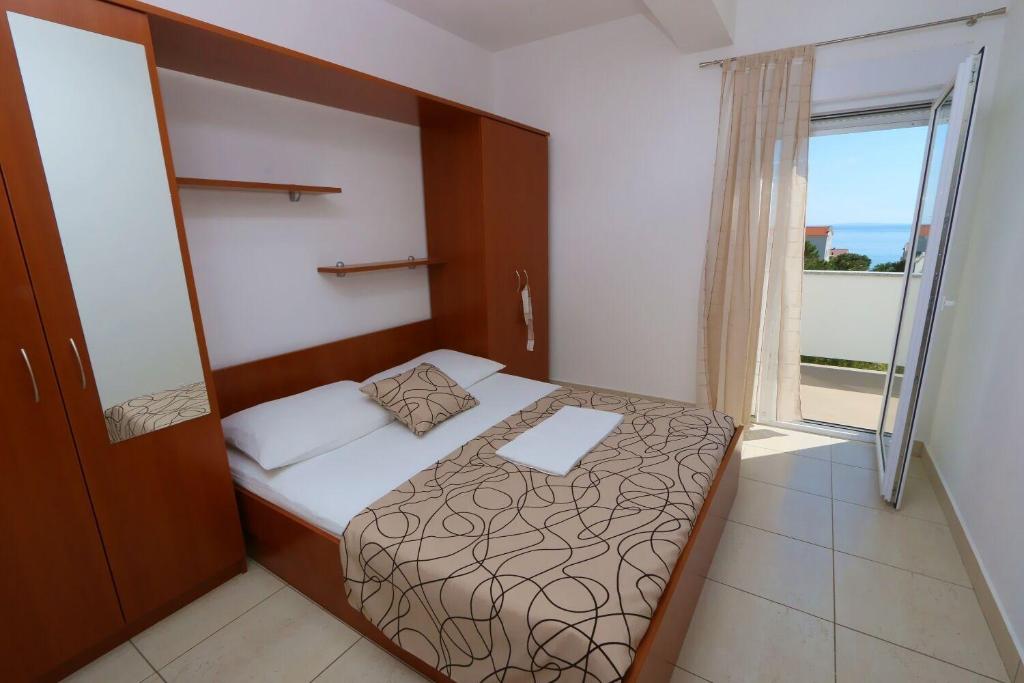 mała sypialnia z łóżkiem i oknem w obiekcie Apartments Boris w Novalji