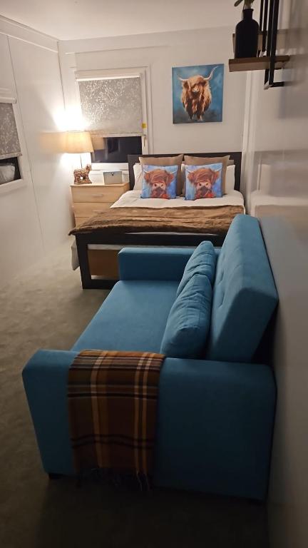 una camera con un divano blu e un letto di Moun Bolton Cabin 'Chester' a Portlaw