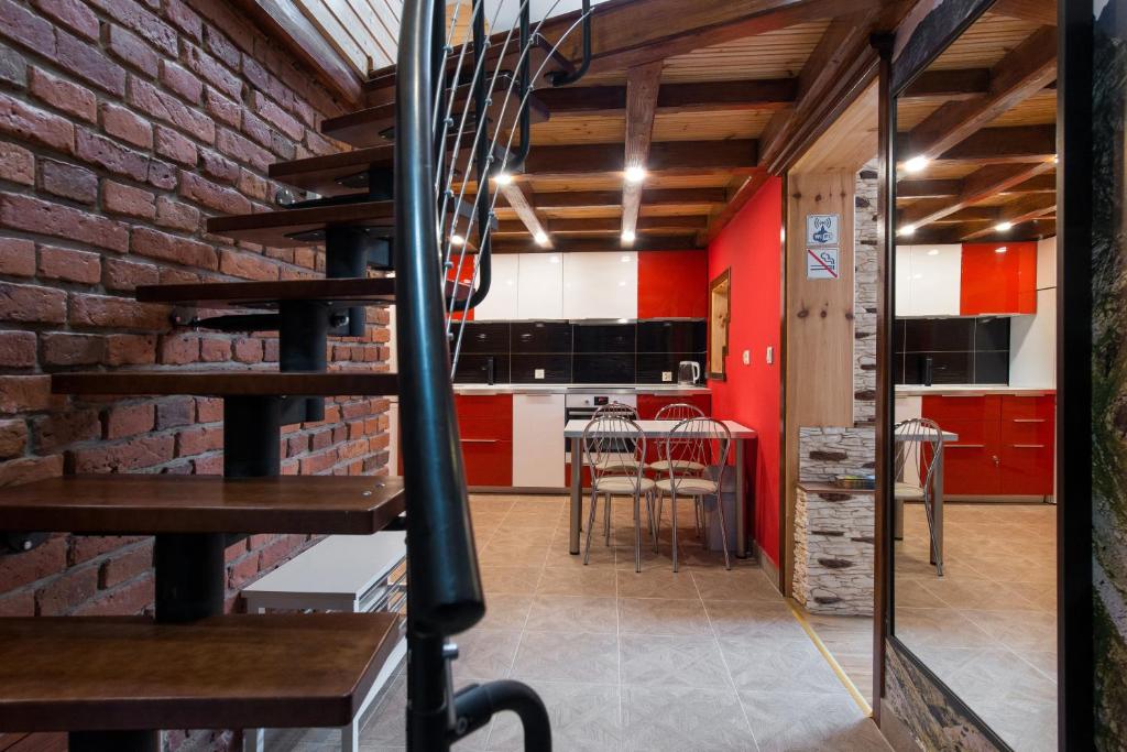 a brick walled kitchen and dining room with red cabinets at Apartment Greg in Krakow