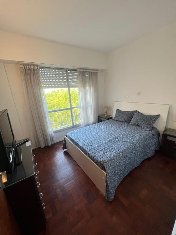 a bedroom with a bed and a large window at Departamento Playa Grande in Mar del Plata