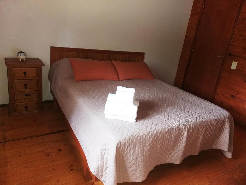 Un dormitorio con una cama con dos toallas encima. en La Almenara Lodge, en Villa General Belgrano