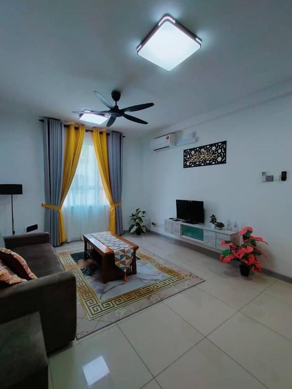 a living room with a couch and a ceiling fan at Teratak Seri Indah in Kuala Terengganu