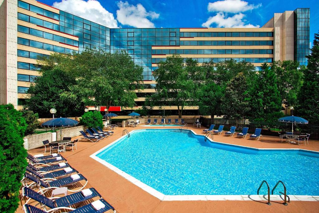 a swimming pool with lounge chairs and a building at Sheraton Imperial Hotel Raleigh-Durham Airport at Research Triangle Park in Durham