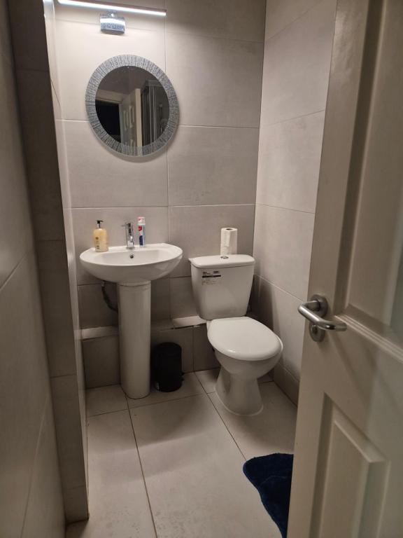 a bathroom with a toilet and a sink and a mirror at 2bed city centre apartment in Limerick