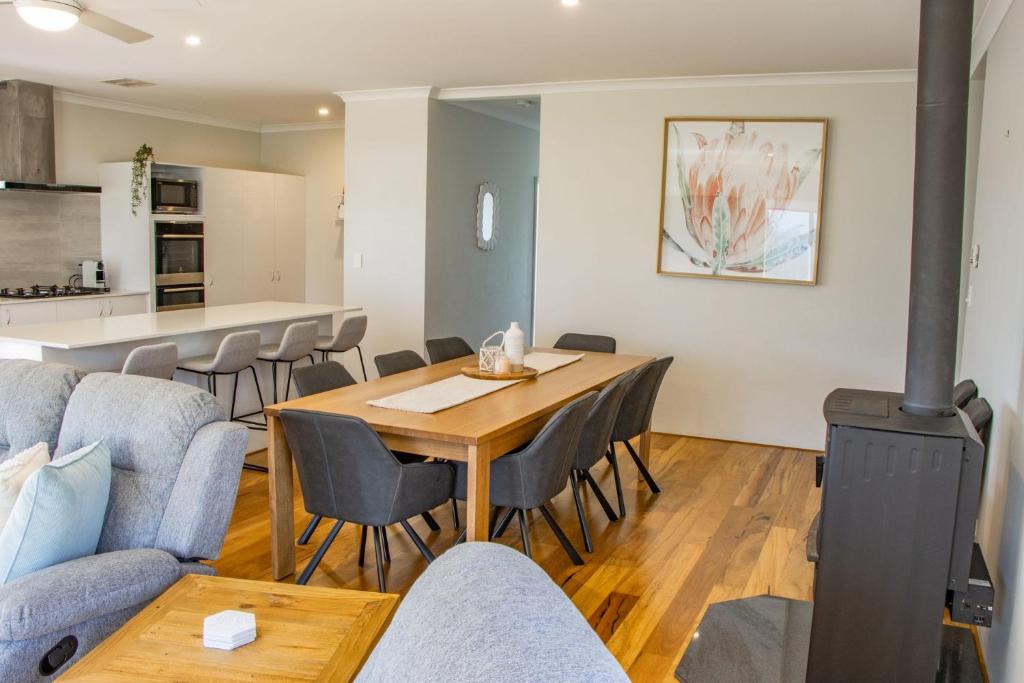 a living room with a table and chairs and a kitchen at Peppermint Rise in Capel