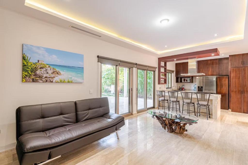 アクマルにあるDepartamento 3, Tulum Country Home, con Muelle de Pesca, Club de Playa, Alberca, Cenote y Campo de Golf, Contrata Day Pass Bahia Principeのソファとキッチンのあるリビングルーム