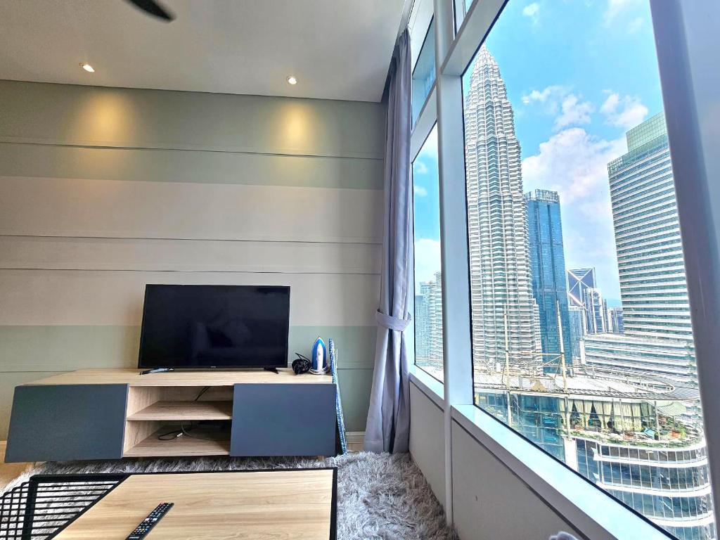 a room with a large window and a television at Apartment Sky by MonoSuites KLCC in Kuala Lumpur