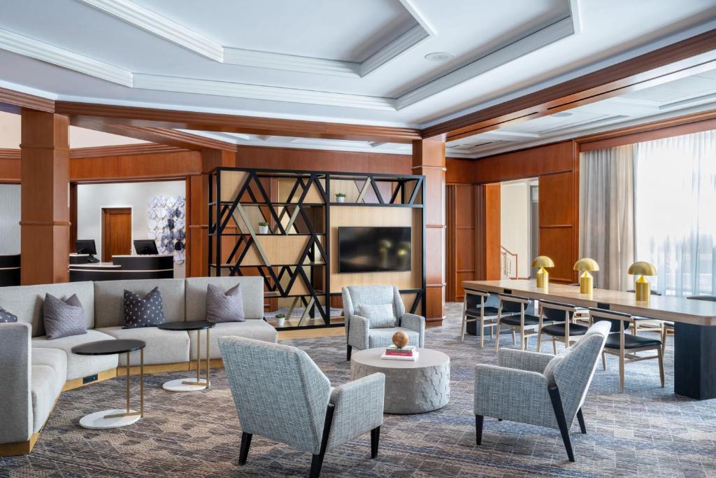 a living room with a couch and chairs and a table at Sheraton Boston Needham Hotel in Needham