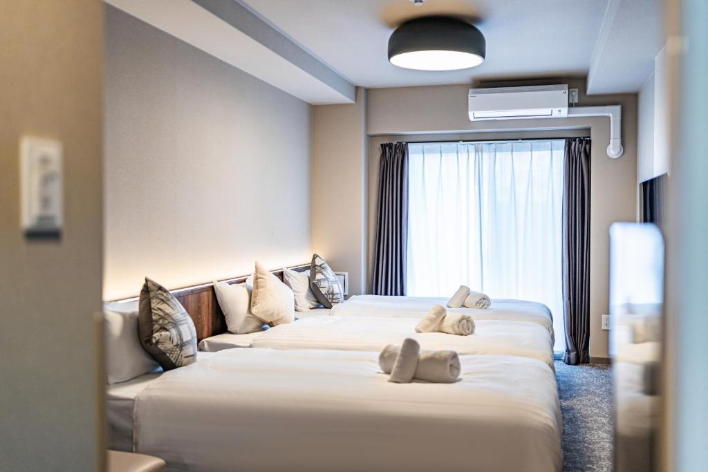 Postel nebo postele na pokoji v ubytování Apartment Hotel 11 Tsutenkaku