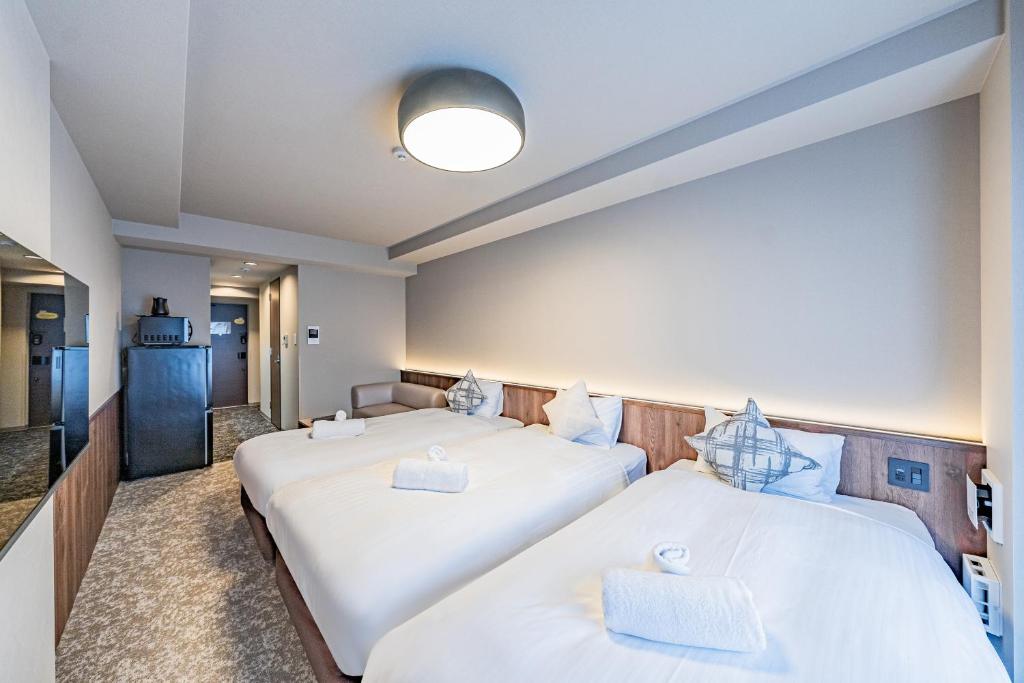 Postel nebo postele na pokoji v ubytování Apartment Hotel 11 Tsutenkaku