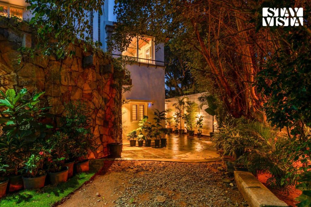 a courtyard of a house with a bunch of plants at StayVista at The Lakeshore with Lake View, WiFi, Garden in Bengaluru