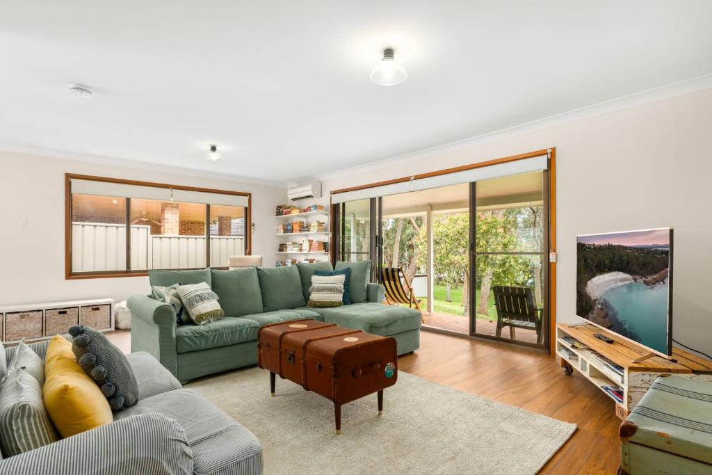 a living room with a couch and a table at Aqua by Experience Jervis Bay in Sanctuary Point